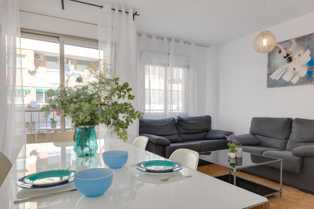 a living room with a table with a vase of flowers at Apartamentos Madrid in Torrevieja