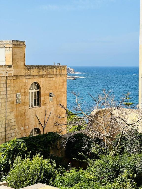 a brick building with the ocean in the background at Sea View apartment in Sliema in Sliema