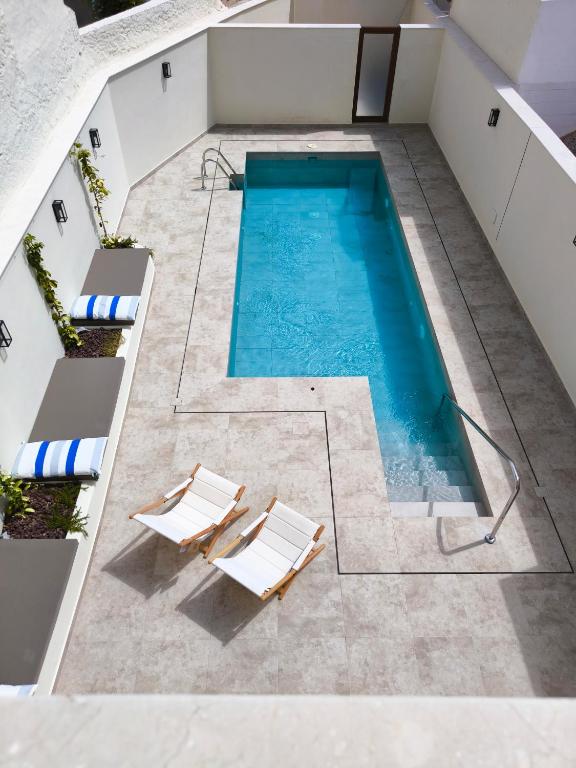 an overhead view of a swimming pool with two chairs at El Jazmín del Patio in Nerja