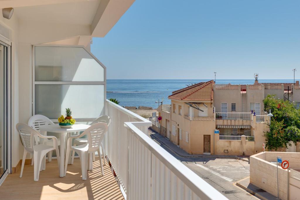 a balcony with a table and chairs and the ocean at La Brisa de Pilar in El Mojón