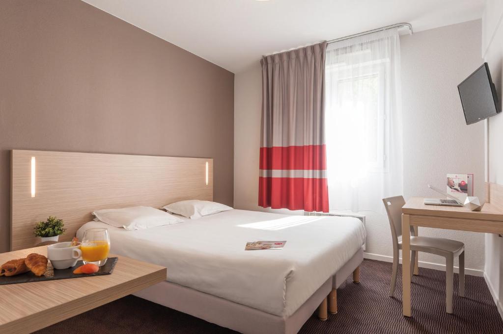 Habitación de hotel con cama, mesa y escritorio. en Appart'City Classic Lyon Part Dieu Garibaldi, en Lyon