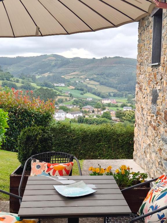 a wooden table and chair with a view of the valley at La casa de atrás in Arancedo