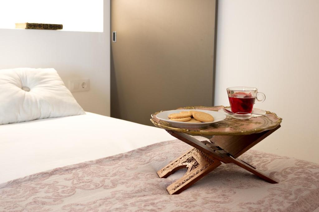 un vassoio con un drink e biscotti su un tavolo accanto al letto di Casa Grimalt a Jalón