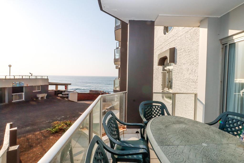 a balcony with a table and chairs and the ocean at Seagull 203 in Margate