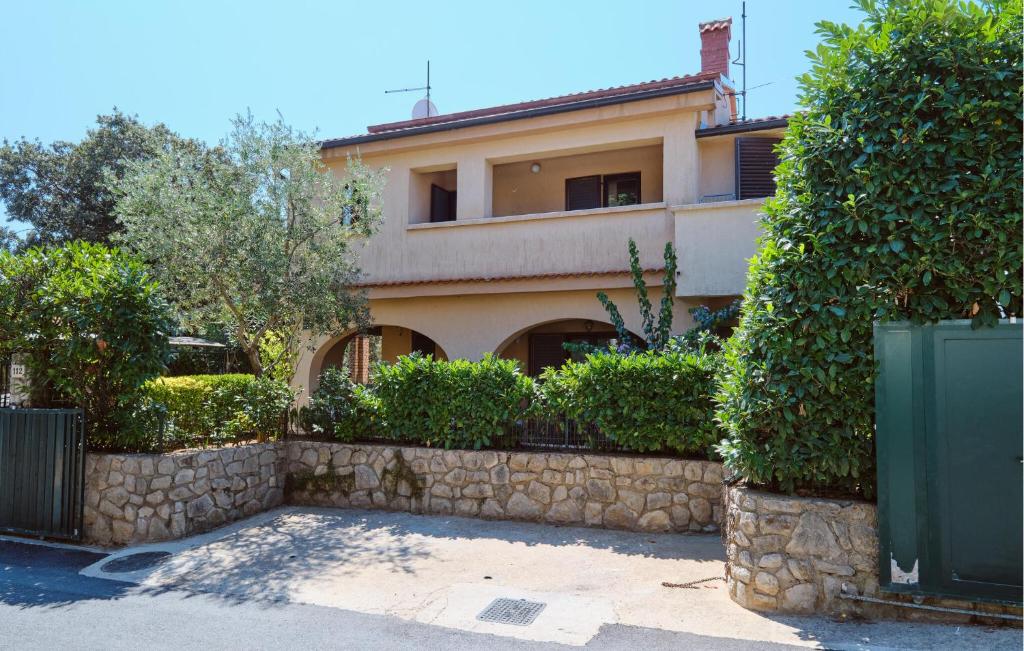 a house with a stone retaining wall and bushes at 3 Bedroom Pet Friendly Apartment In Artatore in Cunski