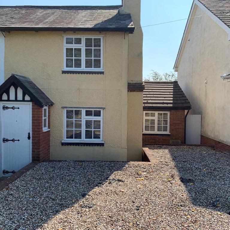 a house with a white door and a driveway at Rosemary cottage in Mountnessing