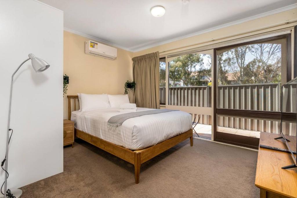 una camera da letto con un letto e un balcone di Compact and Convenient Unit - Hosted by Canstay a Canberra