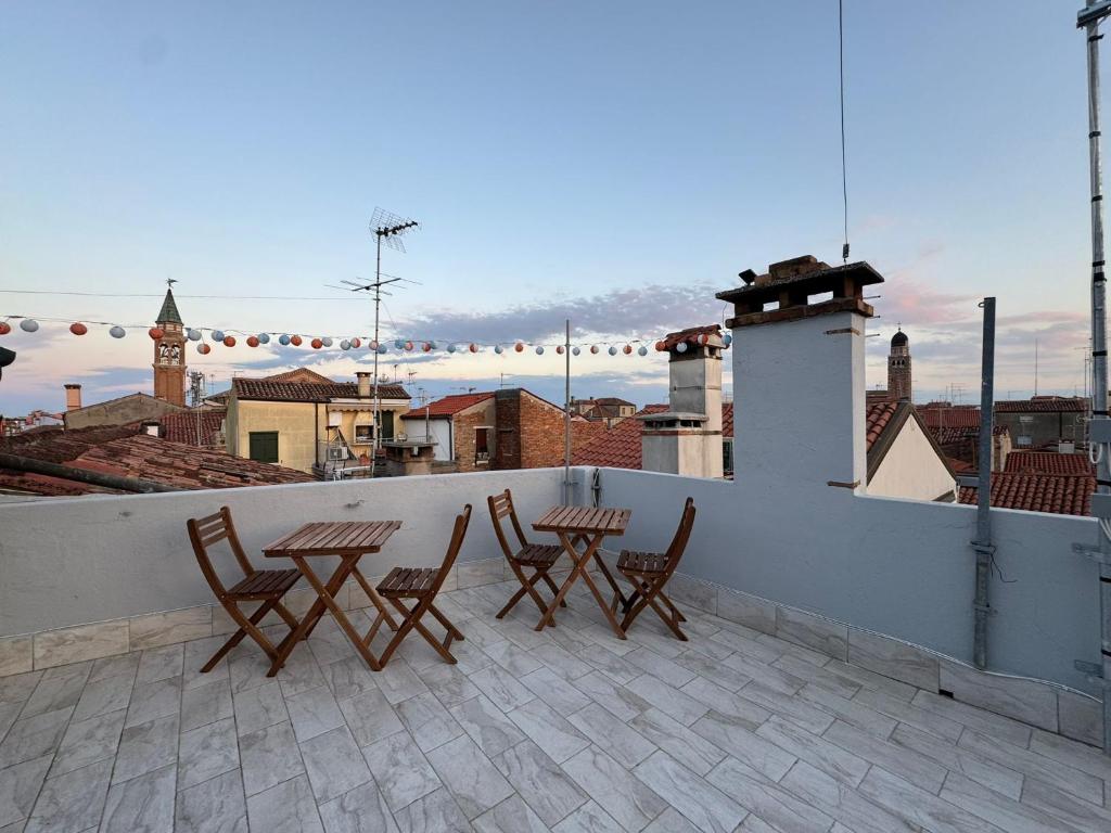 a patio with chairs and tables on a roof at CASA LILLY camere matrimoniali con bagno privato in Chioggia