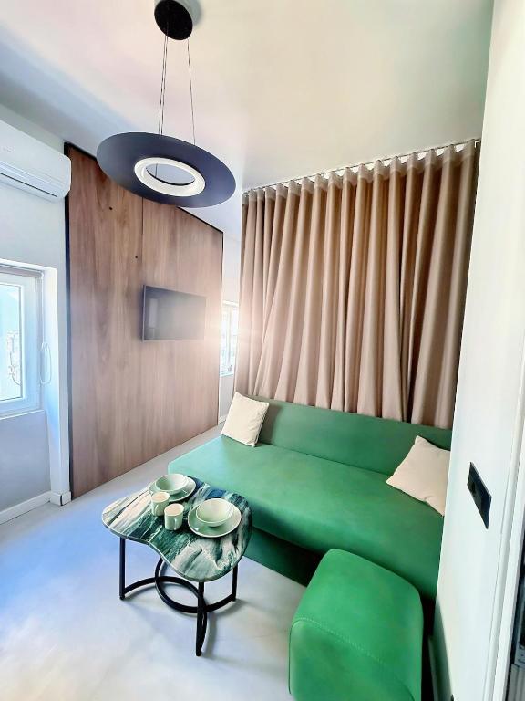 a living room with a green couch and a table at Tirana Essence Apartment in Tirana