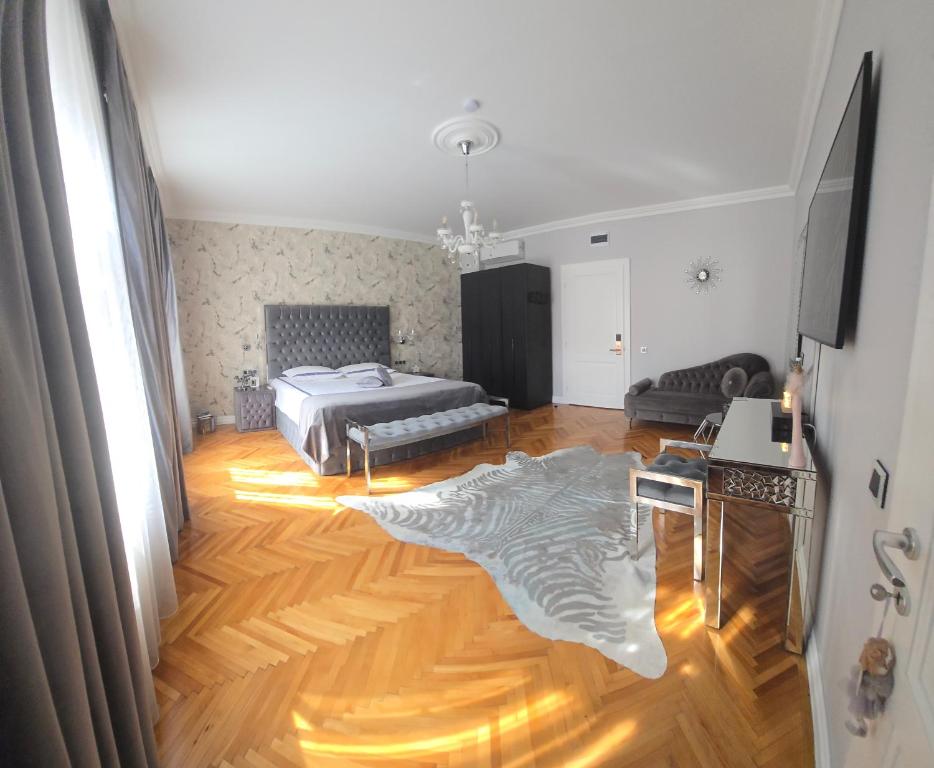 a living room with a bed and a wooden floor at FLH - Fancy Flats near Big Square in Sibiu