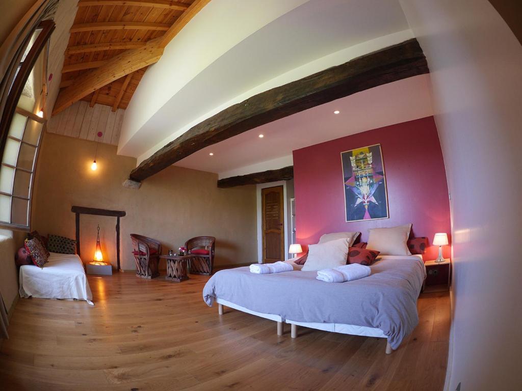 1 dormitorio con 1 cama grande en una habitación en Les Fous du Village, en Saint-Esteben