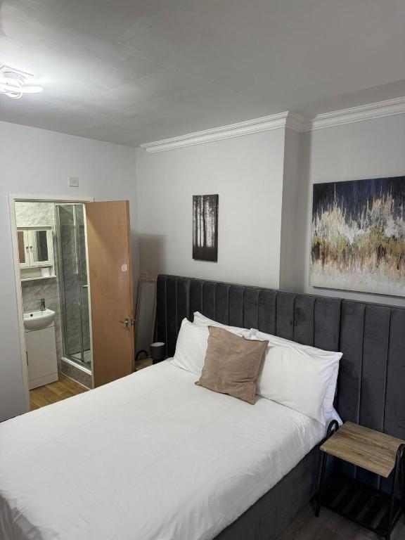 a bedroom with a large bed with white sheets at 247 Serviced Rooms Self catering in Newport