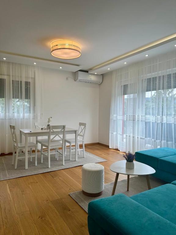 Una sala de estar con una mesa y un sofá azul. en VIP House 4, en Vrnjačka Banja