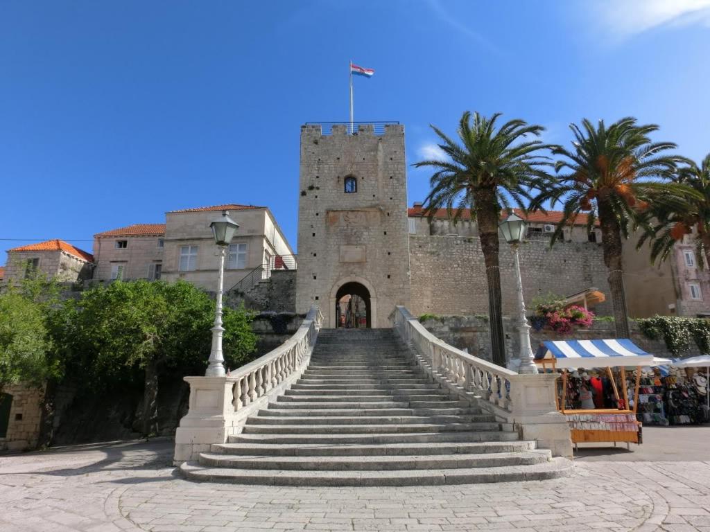 un escalier menant à un bâtiment avec une tour dans l'établissement Ivana Apartment, à Korčula