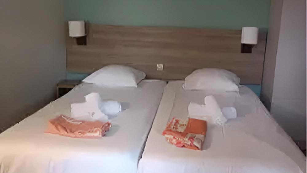 a white bed with two boxes on top of it at VVF Plaine d'Alsace Obernai Strasbourg in Obernai