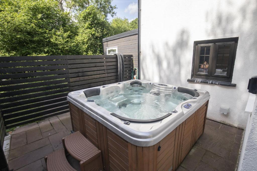 a jacuzzi tub sitting on a patio at Tranquil Cottage with Hot Tub in Skenfrith