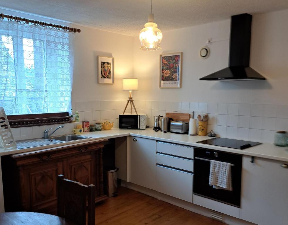 a kitchen with a sink and a stove top oven at Bel appartement au centre in Huelgoat