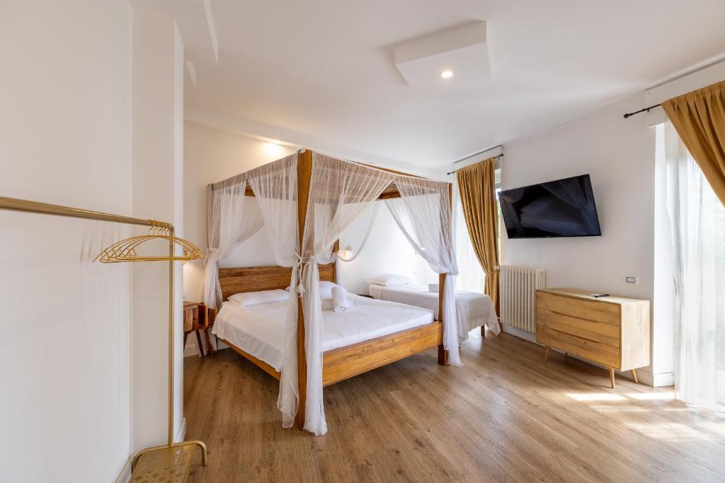 una camera da letto con letto a baldacchino e televisione di Domino Hotel a Torino