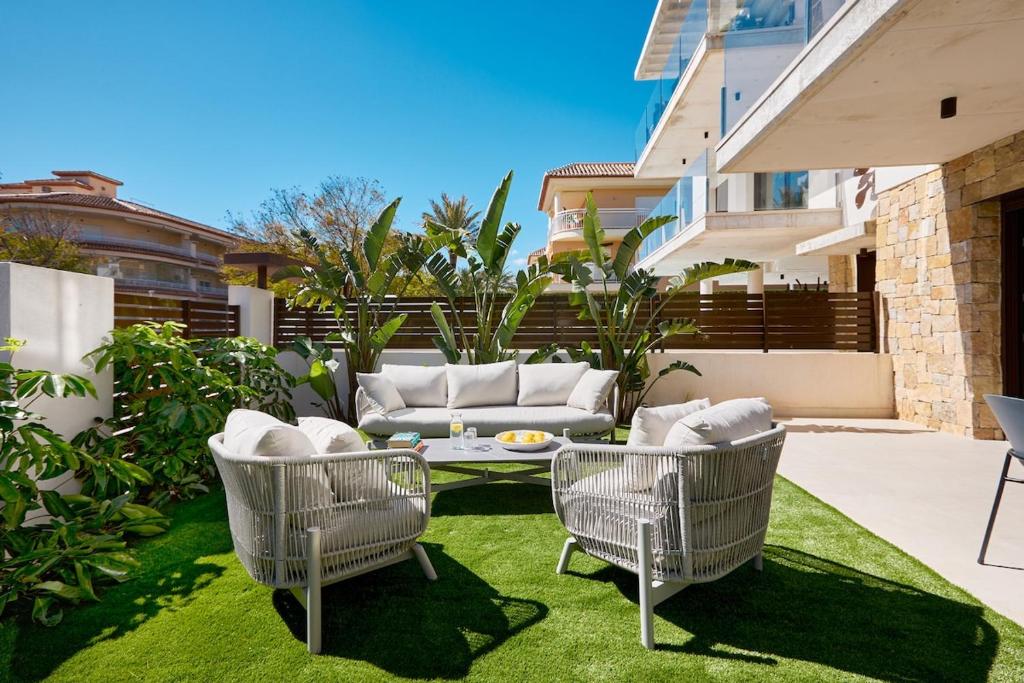 ハベアにあるLuxury apartment Tamana Garden - by Welcomelyの芝生の上にソファと椅子が備わるパティオ