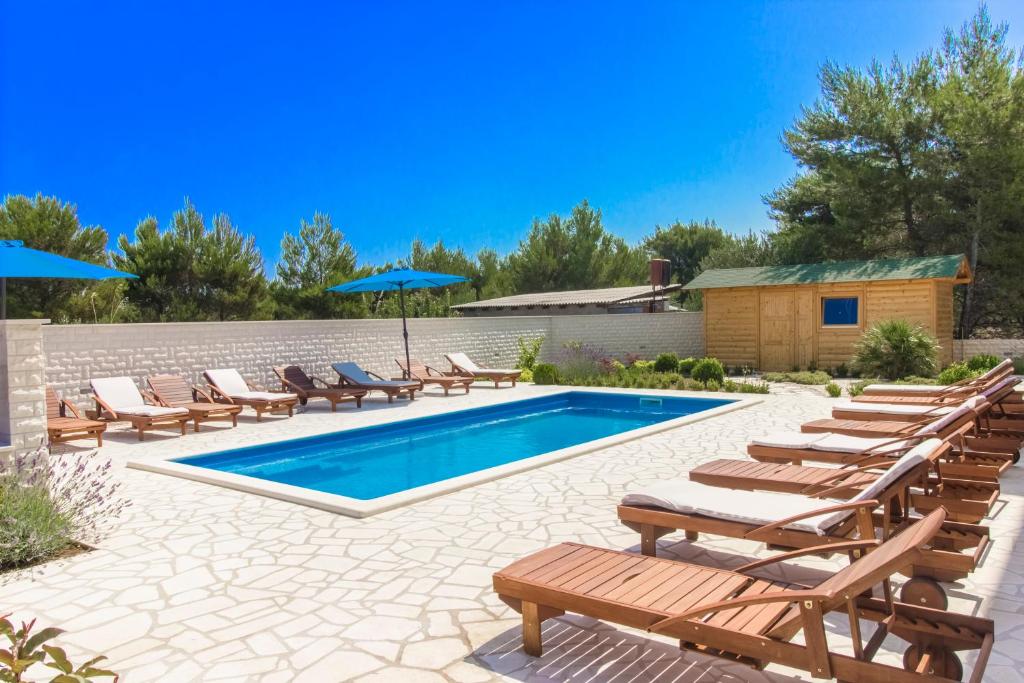 a pool with chaise lounge chairs and a group at Apartment Royal in Vodice