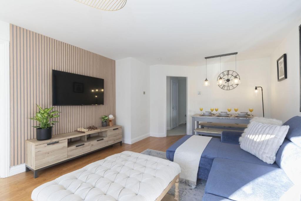 a living room with a couch and a tv at Cosy 2-Bed Apartment in Tivoli in Cheltenham