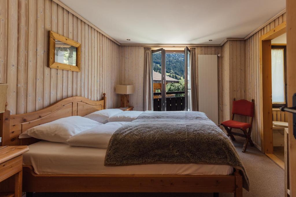 een slaapkamer met een groot bed en een raam bij Hotel Sanetsch in Gsteig