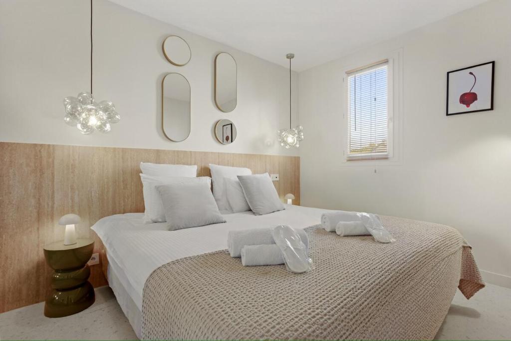 Un dormitorio blanco con una cama grande con dos toallas encima. en Beautiful suite - center of St Tropez, en Saint-Tropez