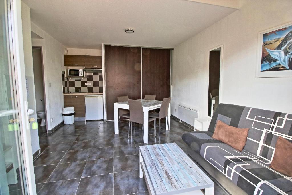 a living room with a couch and a table at Villa F2 piscine et jardin - Saint-Cyprien in Saint-Cyprien