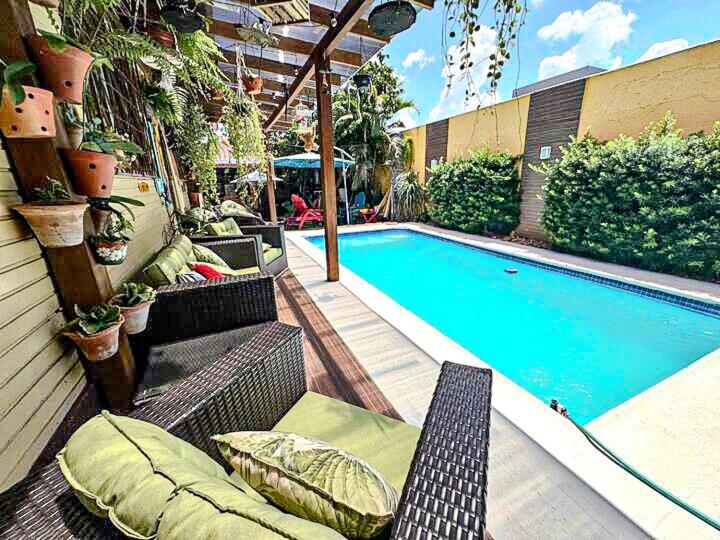 a swimming pool with benches next to a house at Cantinho da Iraci in Foz do Iguaçu