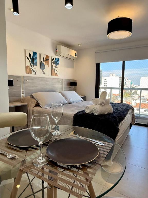 a bedroom with a bed and a table with wine glasses at Luxury Studio in Salta