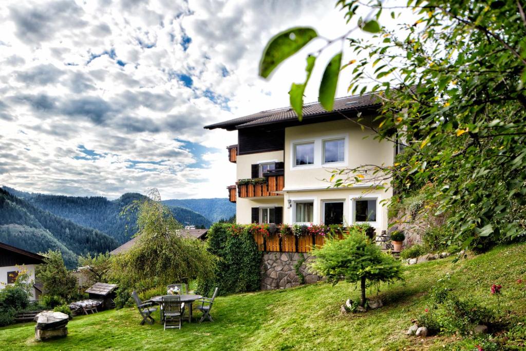 una casa en una colina con una mesa y sillas en Villa Gottfried B&B en Eggen