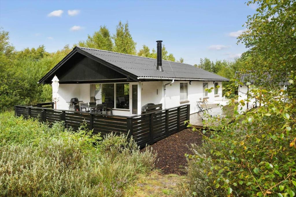 a small white house with a black roof at 0167-Romo-Julianehab-12 in Høm