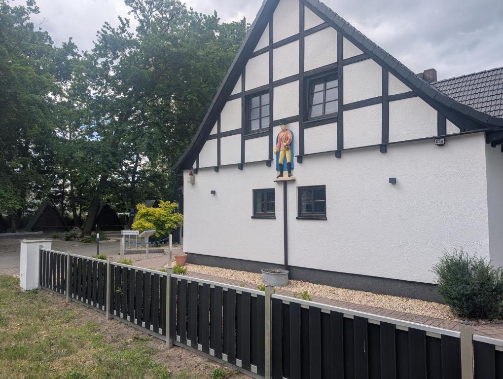 Un edificio blanco con un mural en el costado. en Hotel Zum Postkutscher, en Cottbus