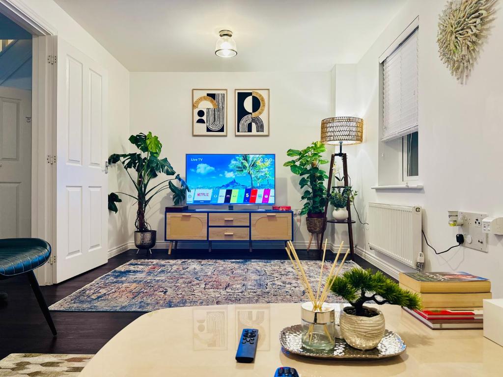 un soggiorno con tv e tavolo di Entire 3-Bed Home, 5 mins to City Centre, Sleeps 6, 2 Free Parking a Colchester