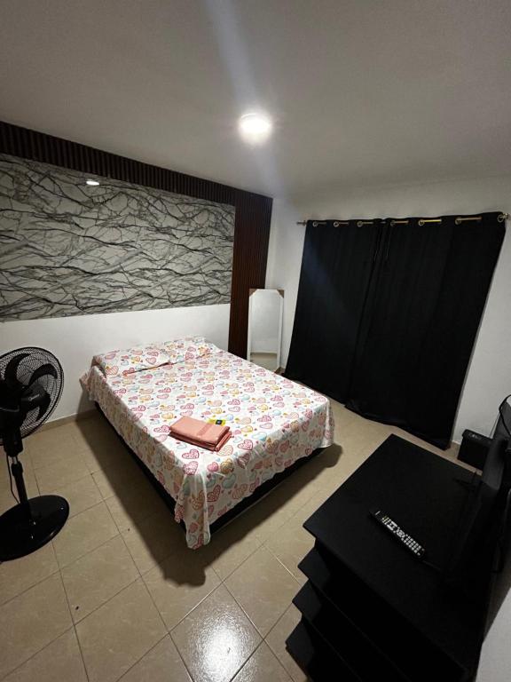 a bedroom with a bed with a candle on it at Cozy private room in Cali's heart in Cali