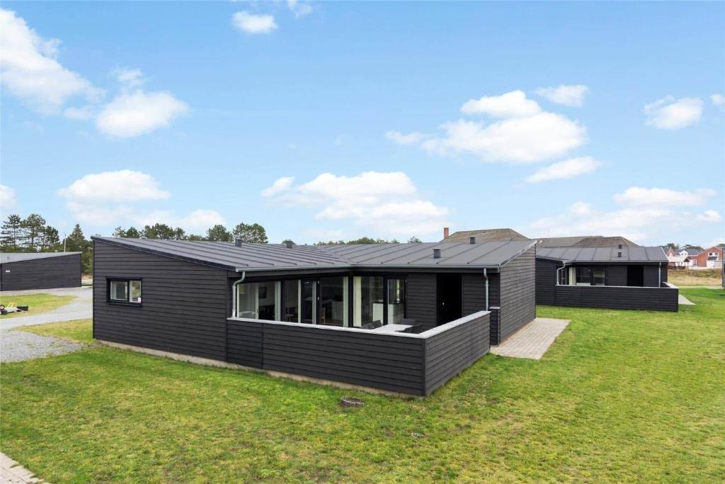 una casa negra en un campo de hierba en 0341-Romo-Vestergade-351, en Sønderby
