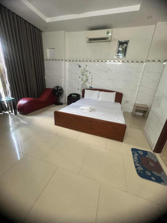 a bedroom with a bed and a red chair at hotel đặng hiền lương in Ho Chi Minh City