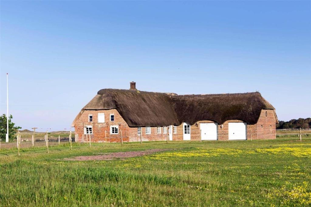 an old brick barn with a thatched roof in a field at 0002-Romo-Juvrevej-89 in Høm