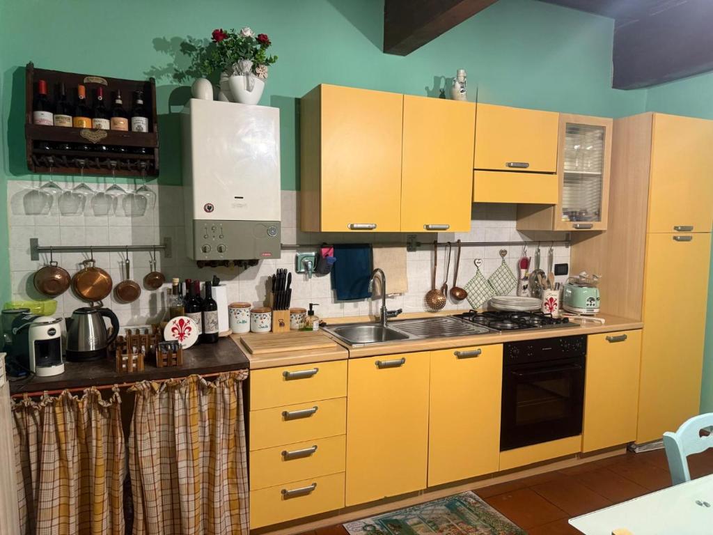 una cocina con armarios amarillos y fregadero en Il nido dei Medici, en Montelupo Fiorentino