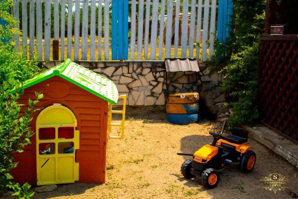 a toy house and a toy motorcycle in a yard at Casa Sofia in Murighiol