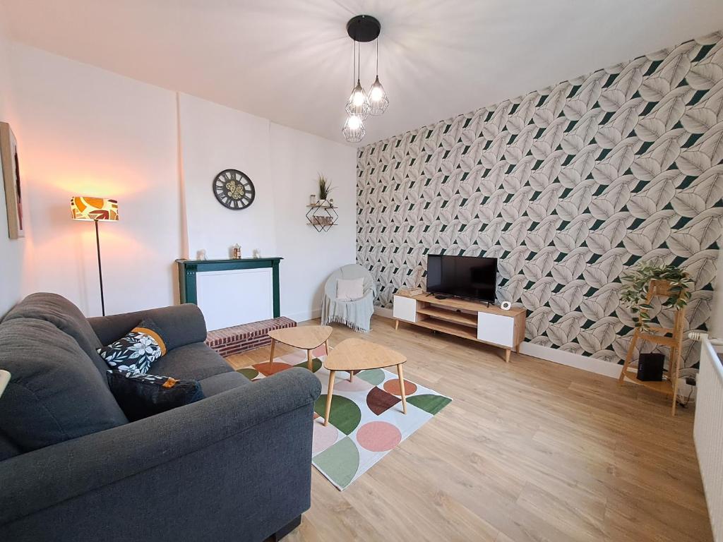 a living room with a couch and a tv at Le 84bis, maison, proche gare, parking, Netflix in Laval