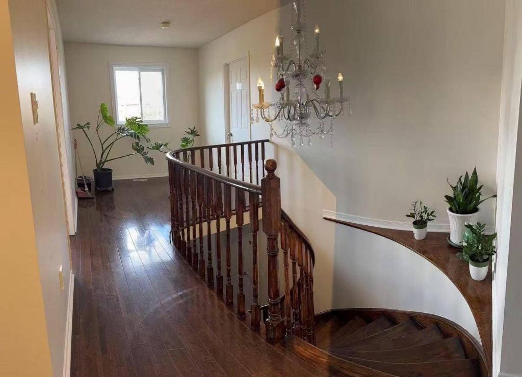 a staircase in a living room with a chandelier at Bright private single bedroom V02 on second floor in Mississauga