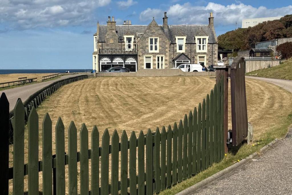 バッキーにあるStrathlene House Retreat - 5 bed deluxe Business or Holiday Accommodationの畑のある家の前の緑のフェンス