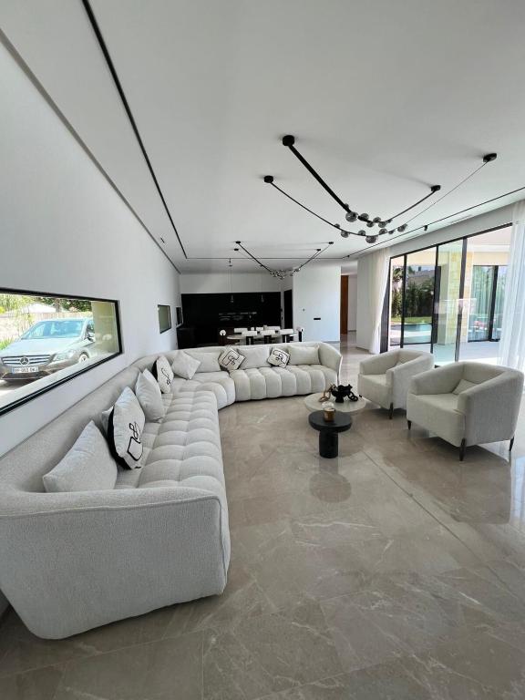 a large living room with white couches and chairs at Villa les palmiers in Marrakesh