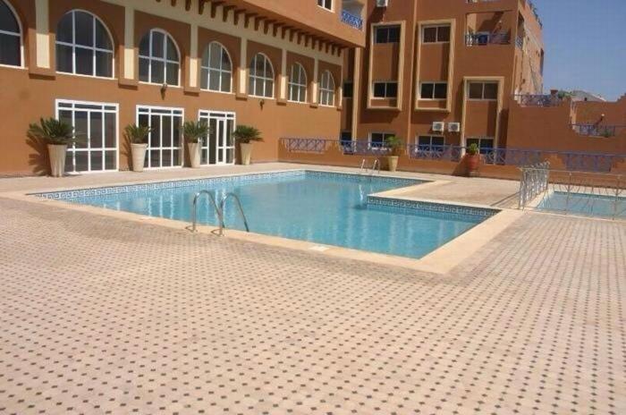 a large swimming pool in front of a building at Appartement OCEAN VIEW in Tamraght Ouzdar