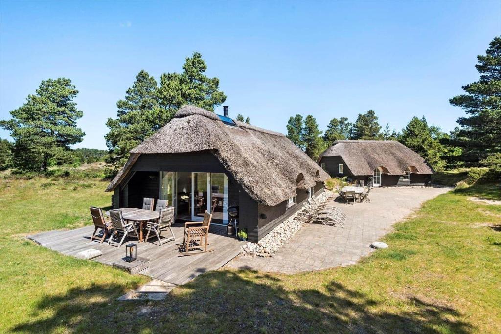 a hut with a table and chairs in a field at 0209-Romo-Vrabyvej-34 in Vesterhede