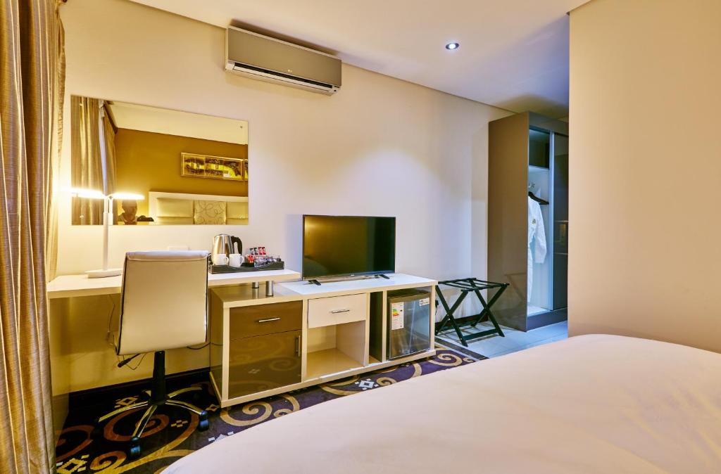 Uma TV ou centro de entretenimento em Palm Continental Hotel