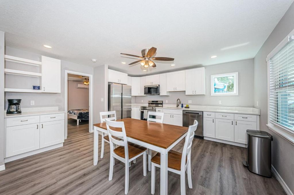 a kitchen with a wooden table and white cabinets at 2 Bedroom Beachside Suite in Clearwater Beach