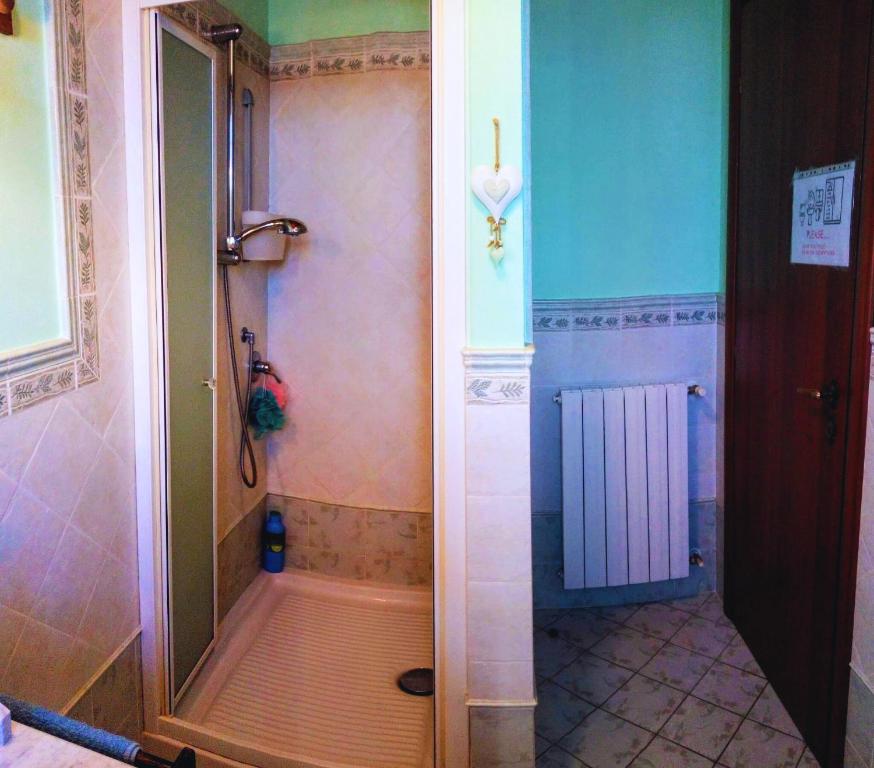 a shower with a glass door in a bathroom at Cozy Valeria's Room in Camaiore