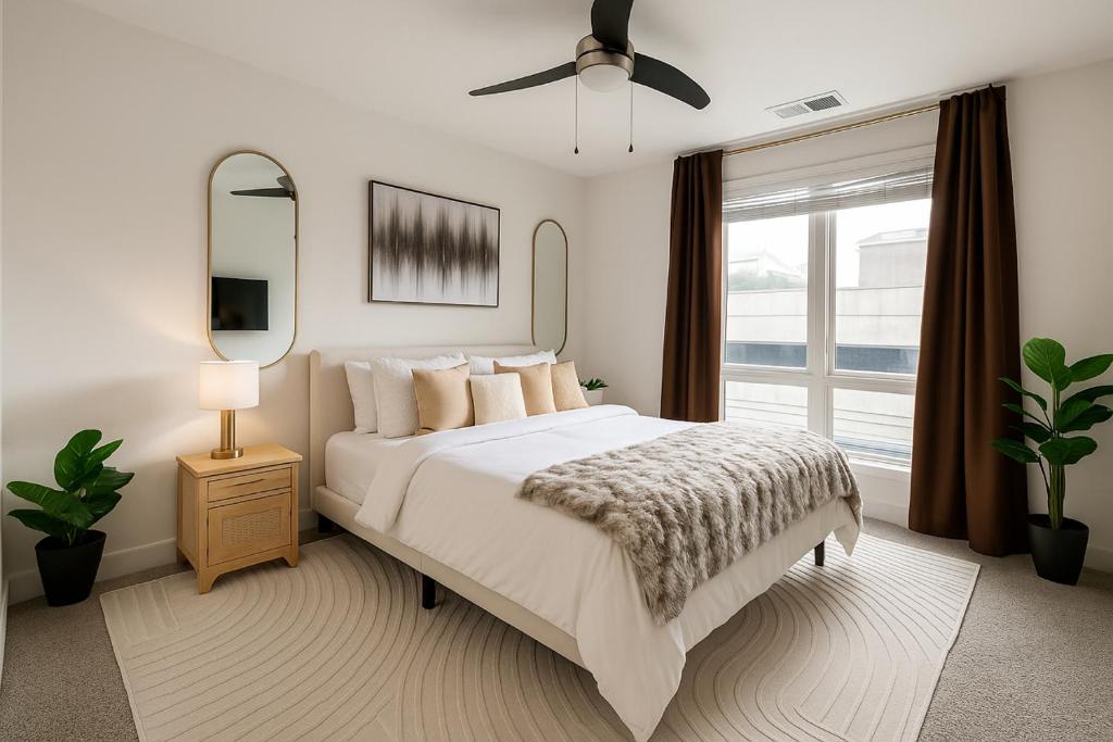 ein weißes Schlafzimmer mit einem Bett und einem Fenster in der Unterkunft Luxury 1BR Atlanta Apartment in Atlanta